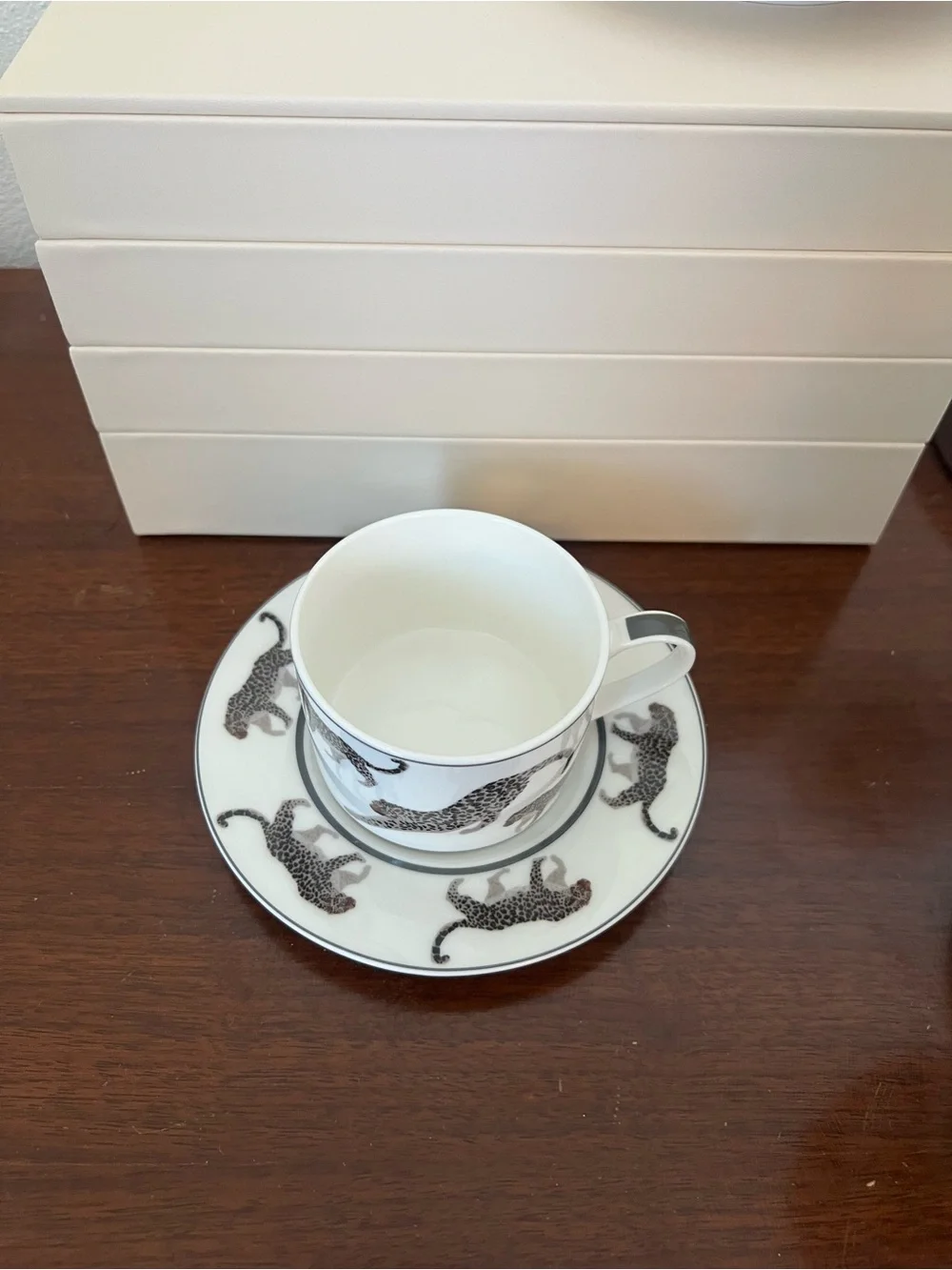 Cup and saucer set with black leopard print on white background